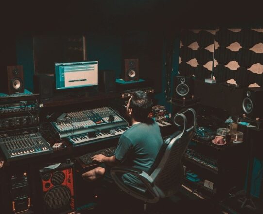 Music producer working alone at a mixing console in a studio