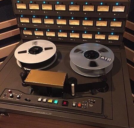 Vintage reel-to-reel tape recorder with magnetic tape reels and meters