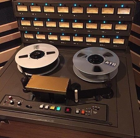 Vintage reel-to-reel tape recorder with magnetic tape reels and meters