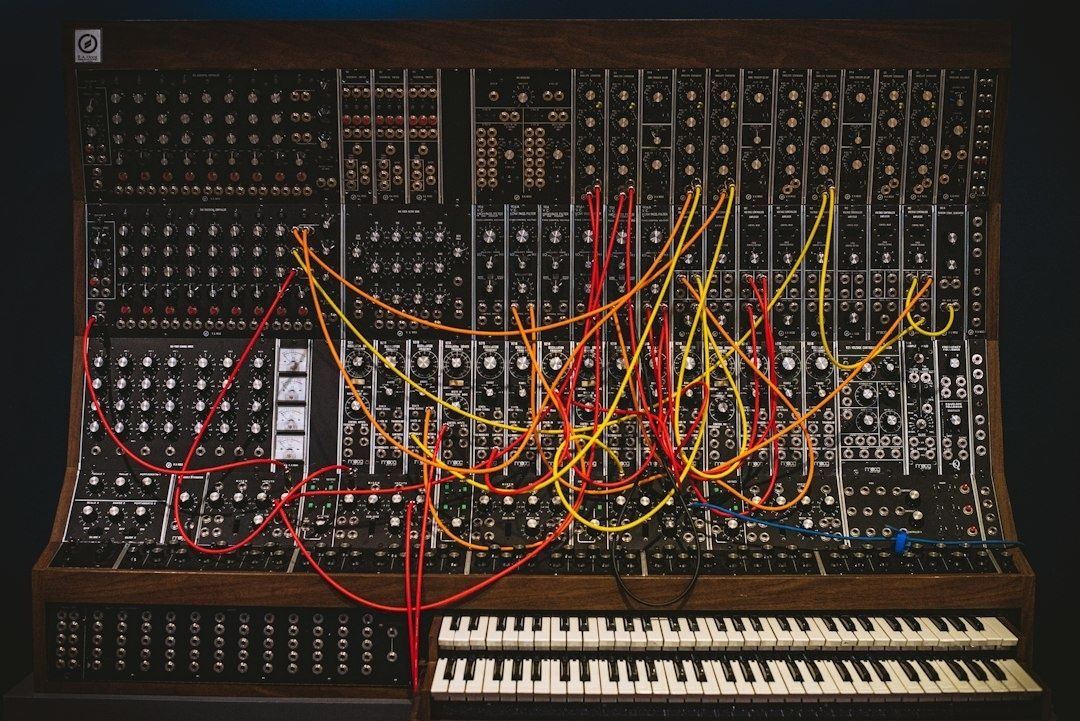 Large modular synthesizer filled with colorful patch cables and two keyboards