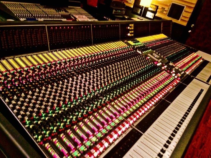 Large analog mixing console with colorful controls in a recording studio